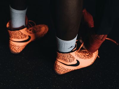 Close-up of athletic shoes on a dark floor.